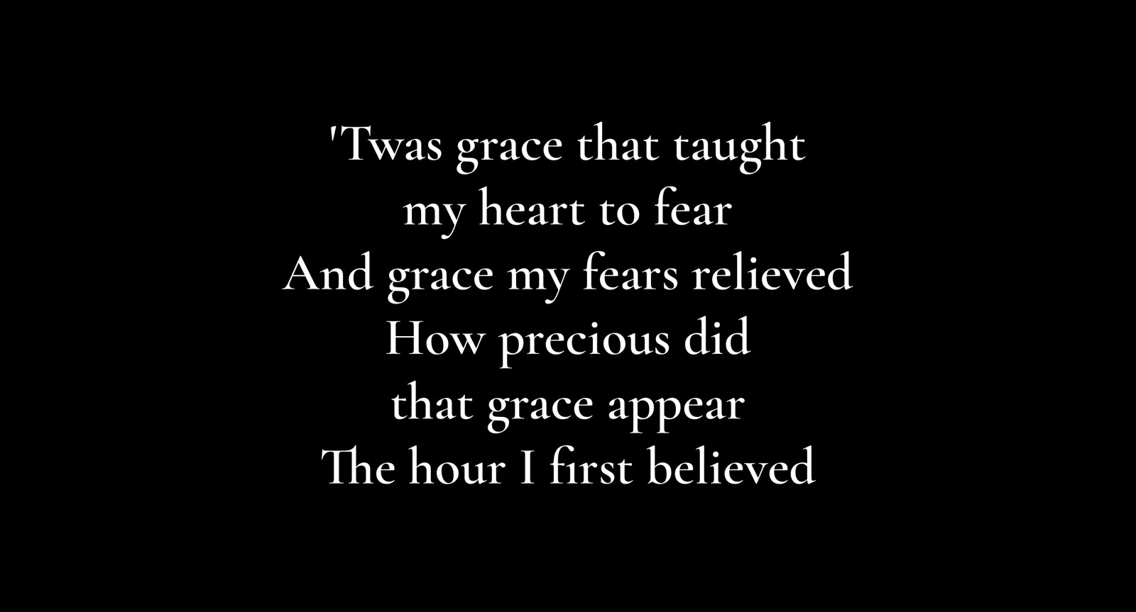 The audience screen: verse 2 of Amazing Grace in large white serif text on black.